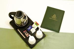 a black tray with a tea pot and a book at Hotel Heera Residency in Bhopal