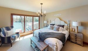 a bedroom with a bed and a chair and a window at Endless Summers Fabulous Lake oasis in Port Severn