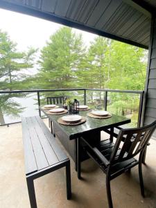a table and a bench on a screened in porch at Family Tides On Six Mile Lake in Port Severn