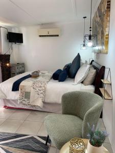 a bedroom with a bed and a chair at Addo Mountain View in Port Elizabeth