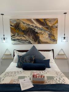1 dormitorio con 1 cama con una pintura en la pared en Addo Mountain View, en Port Elizabeth