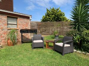 a yard with two chairs and a table and a fence at Addo Mountain View in Port Elizabeth
