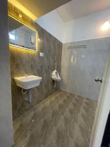 a bathroom with a sink and a mirror at Caribbean Island Home Stay in Mahabalipuram