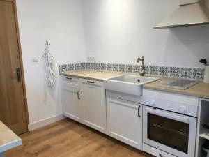 a kitchen with white cabinets and a sink at Villa Petit Caprice - Piscine privée au calme dans jardin arboré in Lanton +15 photos