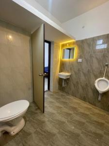 a bathroom with a toilet and a sink and a urinal at Caribbean Island Home Stay in Mahabalipuram
