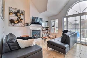 a living room with a couch and a fireplace at Chalet Saint-Sauveur with heated pool! in Saint-Sauveur-des-Monts
