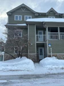 a house with snow in front of it at Chalet Saint-Sauveur with heated pool! in Saint-Sauveur-des-Monts