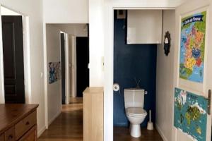 een badkamer met een toilet en een blauwe muur bij Appartement de standing calme idéal pour les JO ! in Suresnes