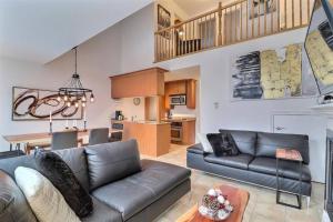 a living room with a couch and a table at Chalet Saint-Sauveur with heated pool! in Saint-Sauveur-des-Monts