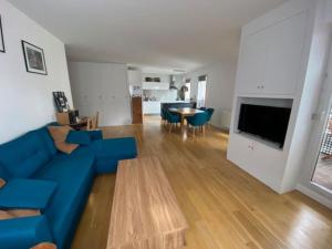 een woonkamer met een blauwe bank en een tafel bij Appartement de standing calme idéal pour les JO ! in Suresnes