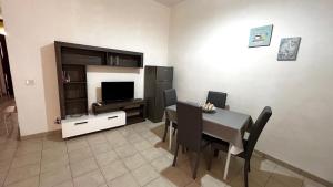 a living room with a dining table and a television at Casa Vacanze Linuccio in Casalabate
