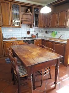 een keuken met een houten tafel en stoelen bij Eremo di Santo Apollinare in Messenano
