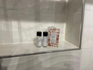 twee producten op een glazen plank in een badkamer bij Pina’s home in Trieste