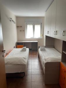 une petite chambre avec deux lits et une fenêtre dans l'établissement Pina’s home, à Trieste
