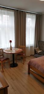 ein Wohnzimmer mit einem Tisch und einer Vase darauf in der Unterkunft Apartamenty Po Kominiarzach in Chełmno