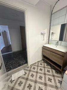 ein Bad mit einer Dusche, einem Waschbecken und einem Spiegel in der Unterkunft Nancy & Vaggelis Holiday Studios in Litochoro