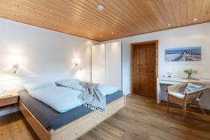 a bedroom with a bed with a wooden ceiling at Deich-Bungalow Königsberger Allee 30 APPARTO Grömitz in Grömitz