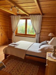 ein Schlafzimmer mit einem Bett in einem Holzzimmer in der Unterkunft Pokoje Gościnne Pod Lipą in Zakopane