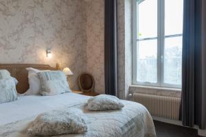 a bedroom with a bed and a window at Manoir de la Roche Torin, The Originals Relais (Relais du Silence) in Courtils
