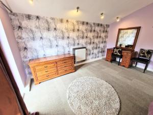 a living room with a dresser and a mirror at Ochil 10 with Private Hot Tub - Fife - Loch Leven - Lomond Hills in Kelty