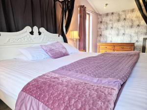 a bedroom with a large white bed with a purple blanket at Ochil 10 with Private Hot Tub - Fife - Loch Leven - Lomond Hills in Kelty