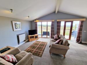 a living room with two couches and a television at Ochil 10 with Private Hot Tub - Fife - Loch Leven - Lomond Hills in Kelty