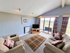 a living room with two couches and a television at Ochil 10 with Private Hot Tub - Fife - Loch Leven - Lomond Hills in Kelty