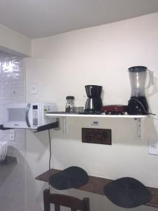 a kitchen with a shelf with pots and pans on it at Residencial Estrela Guia 2 in Cabo Frio