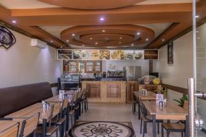 a restaurant with wooden tables and chairs and a counter at Vinetea Hotel in Kampala