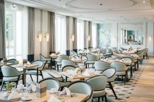 a dining room filled with tables and chairs at Hotel Atlantic Hamburg, Autograph Collection in Hamburg
