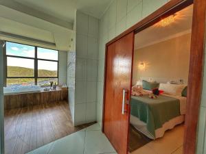 a bathroom with a bed and a bath room at Hotel Aconchego do Velho Chico in Piranhas