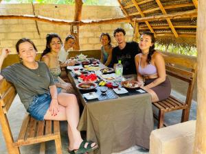 un grupo de personas sentadas alrededor de una mesa con comida en Maika safari lodge, en Udawalawe
