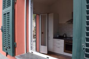 迪亞諾馬里納的住宿－Casa a Diano con giardino，厨房设有一扇门,可通往带炉灶的厨房