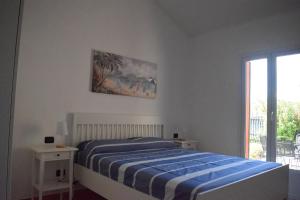 迪亞諾馬里納的住宿－Casa a Diano con giardino，白色的卧室设有床和窗户