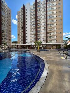 una gran piscina con edificios altos en el fondo en Caldas Novas - Condominio Casa da Madeira - ate 5 pessoas - PERMITIDO descer com bebida para o parque - Centro, en Assis