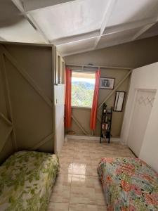 a small room with a bed and a window at Adella's Blue Mountain Coffee Farmstay in Kingston