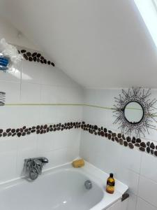a bathroom with a bath tub and a mirror at Maison avec Jardin proche Porte Maillot in Colombes
