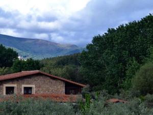 a stone house with mountains in the background at Finca Vergel in Gata