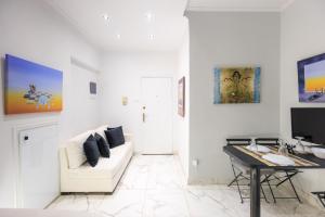 a white living room with a white couch and a desk at Aiolos luxury in the centre of plaka in Athens