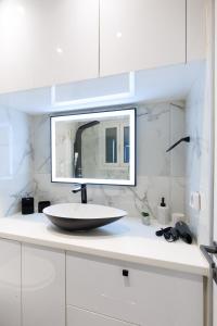 a white bathroom with a sink and a mirror at Aiolos luxury in the centre of plaka in Athens