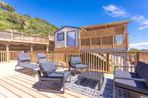 a deck with chairs and a tiny house at Domaine Ile d'or, bungalow Segur 8 in Saint-Raphaël