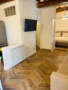 een woonkamer met houten vloeren en een flatscreen-tv bij Dreaming Perugia in Perugia
