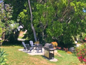 a patio with chairs and a grill in a yard at Spanish charm guest apartment at villa with great location! in Las Lagunas Mijas