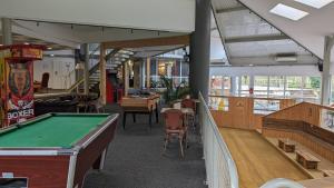 a room with a pool table and some chairs at Hotel Restaurant La Dame du Lac in Monflanquin