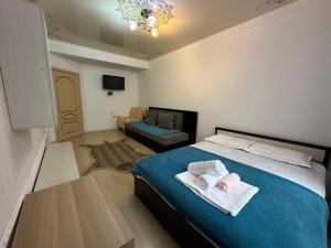Rakhat的住宿－ЖК Сезам，一间带床和沙发的小卧室