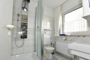 Un baño blanco con ducha y WC. en Ferienwohnung-Eilts-Whg-10, en Borkum