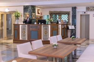 restauracja z drewnianymi stołami i białymi krzesłami w obiekcie Hotel Royal w Wiedniu