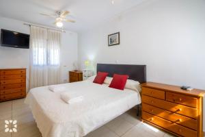 sypialnia z łóżkiem z czerwonymi poduszkami i komodą w obiekcie Villa Airlie by Abahana Villas w mieście Calpe +19 zdjęć