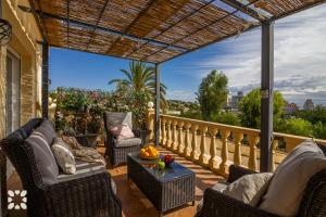 patio z krzesłami i stołem na balkonie w obiekcie Villa Airlie by Abahana Villas w mieście Calpe
