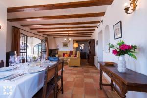 a dining room with a long table with flowers on it at Villa Albatros by Abahana Villas in Benissa